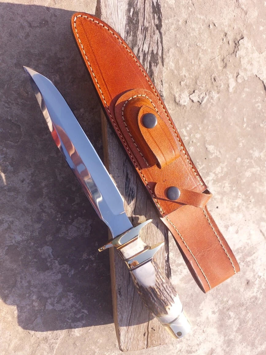 High-quality carbon steel hunting knife featuring a mirror finished blade, natural stag handle, and brass guard. Delivered with a durable stitched leather sheath, this knife is suitable for hunters, survivalists, and knife collectors.