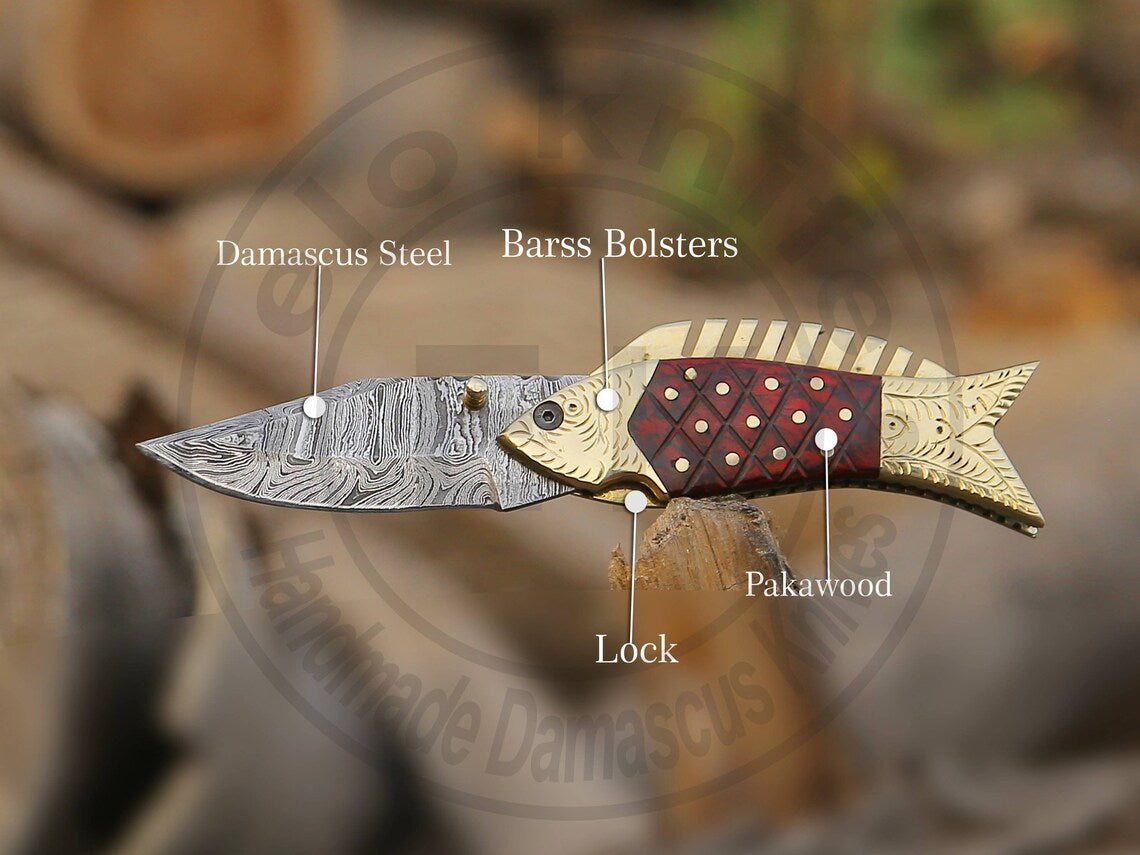 Close-up of Damascus steel pattern and decorative brass engraving on fish handle.