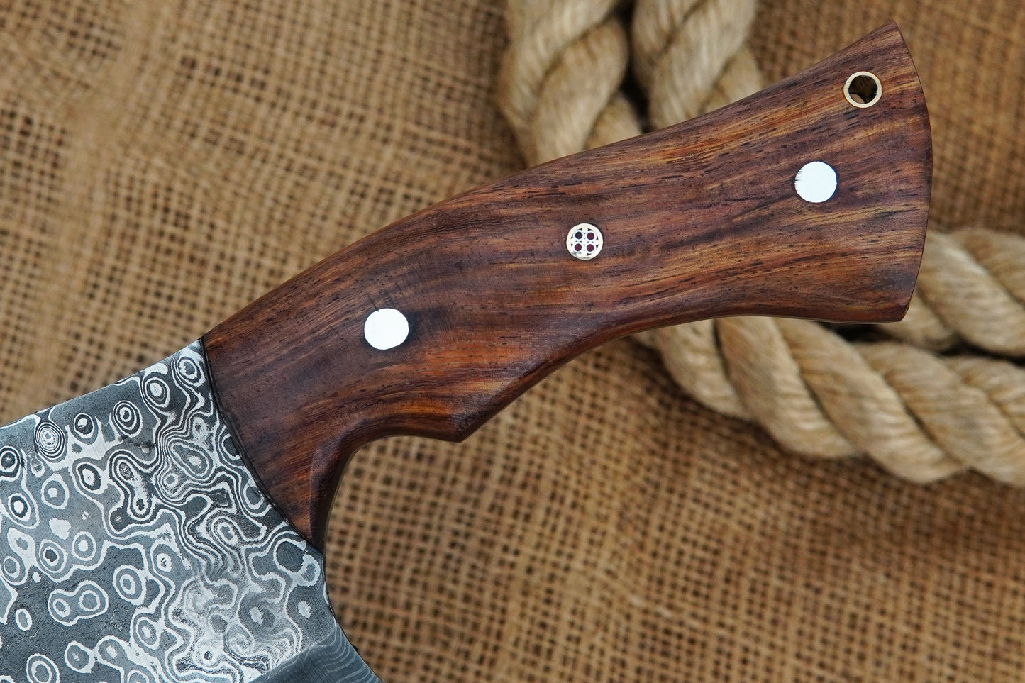 This Serbian chopper is hand-forged from Damascus steel with a full tang blade and rose wood handle for comfort and grip. A versatile knife for kitchen, BBQ, or camping. Engraving available free of charge.
