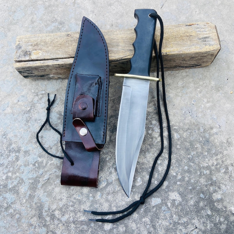 Handmade Bowie knife crafted from 5160 spring steel featuring a black micarta handle and brass guard. Includes a dark brown leather sheath with secure snap closure. Ideal for hunting, camping, and survival. Each knife is hand-forged for maximum toughness and balance, offering superior edge retention. Perfect for collectors or as a personalized gift for men who appreciate craftsmanship and performance.