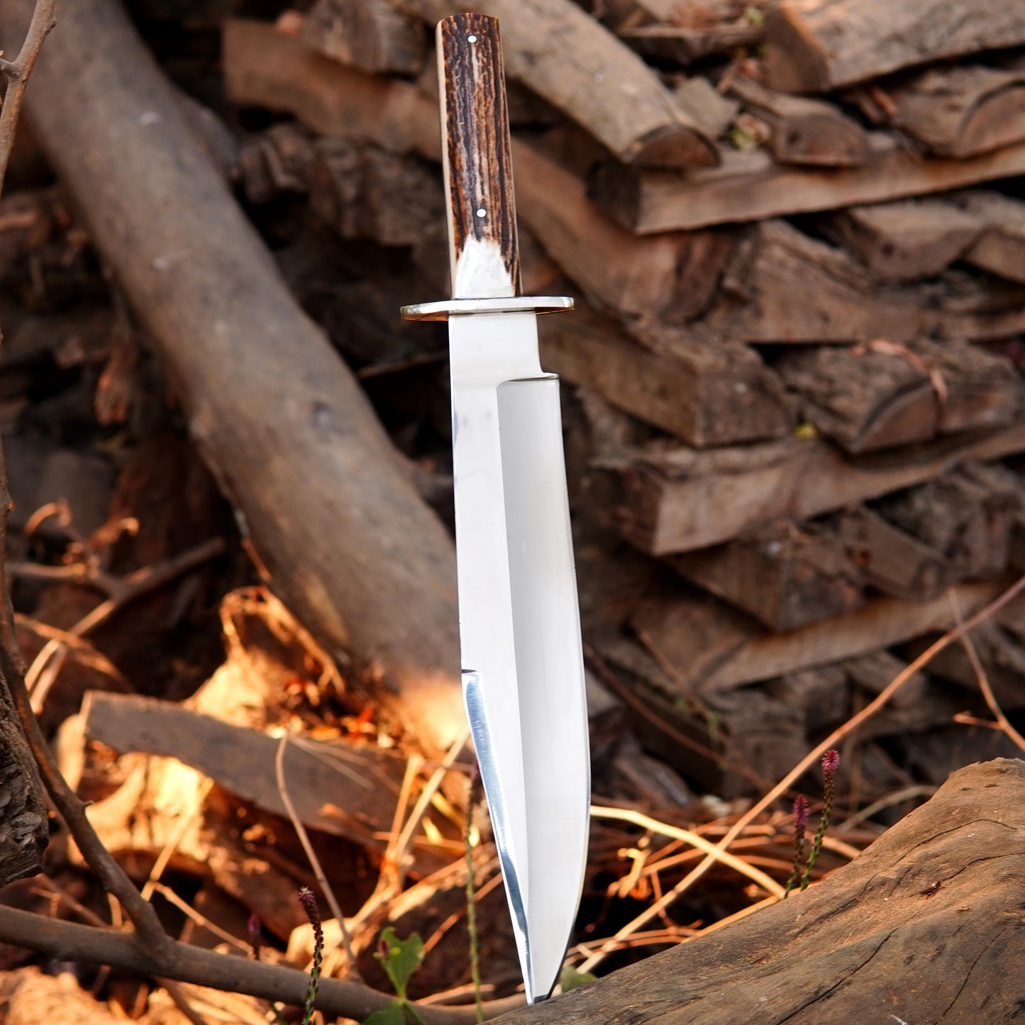 Traditional hunting knife positioned near campfire wood background highlighting blade finish.