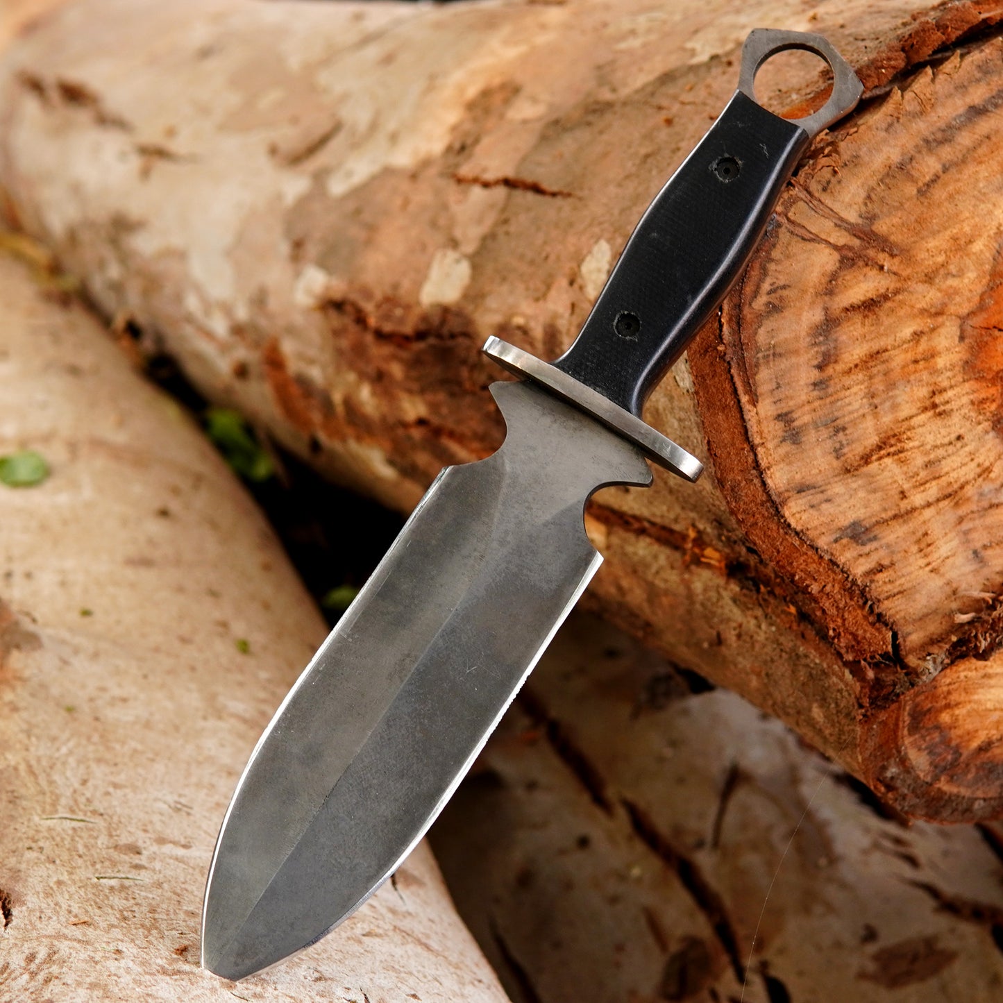Outdoor survival knife displayed in natural environment highlighting durability and strength.