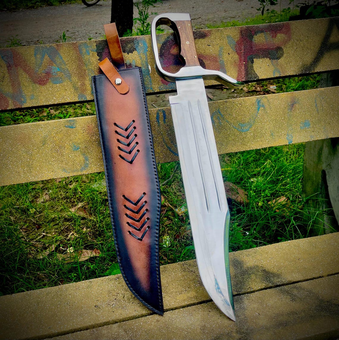 Handmade heavy D-Guard Bowie knife with carbon steel blade and rosewood handle displayed outdoors.
