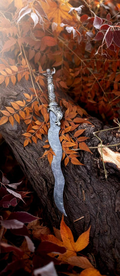 Artistic shot of handmade Damascus knife displayed on a wooden surface for fantasy collection appeal.