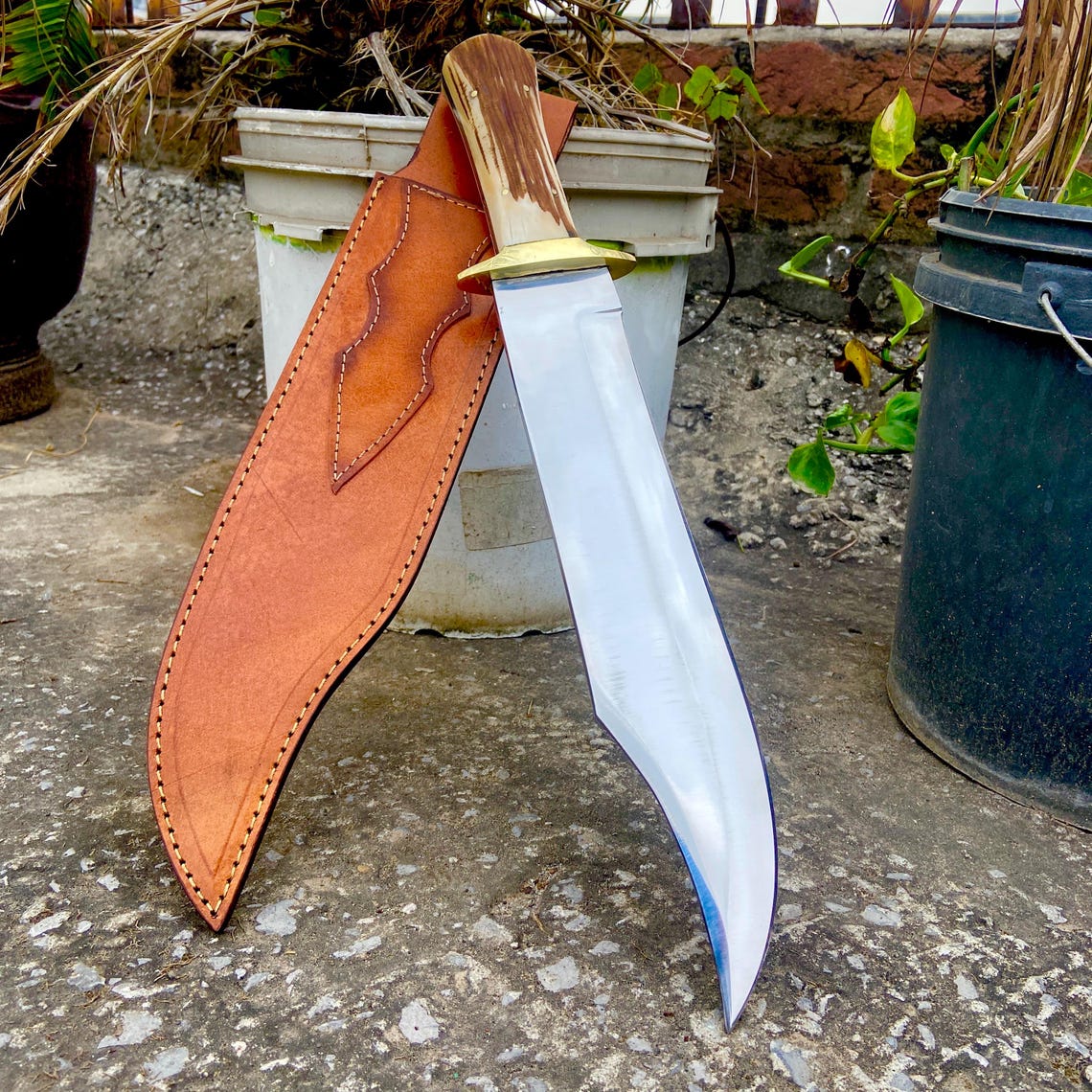 Bowie knife inside hand-stitched leather sheath showing sheath detail and belt loop.