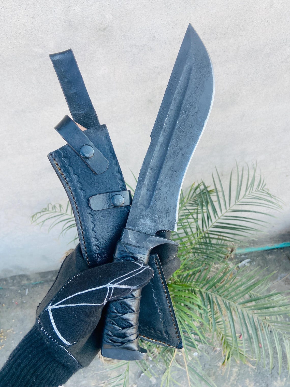 Angled shot showing sweeping belly profile of the blade for camp and field tasks, with sheath beneath