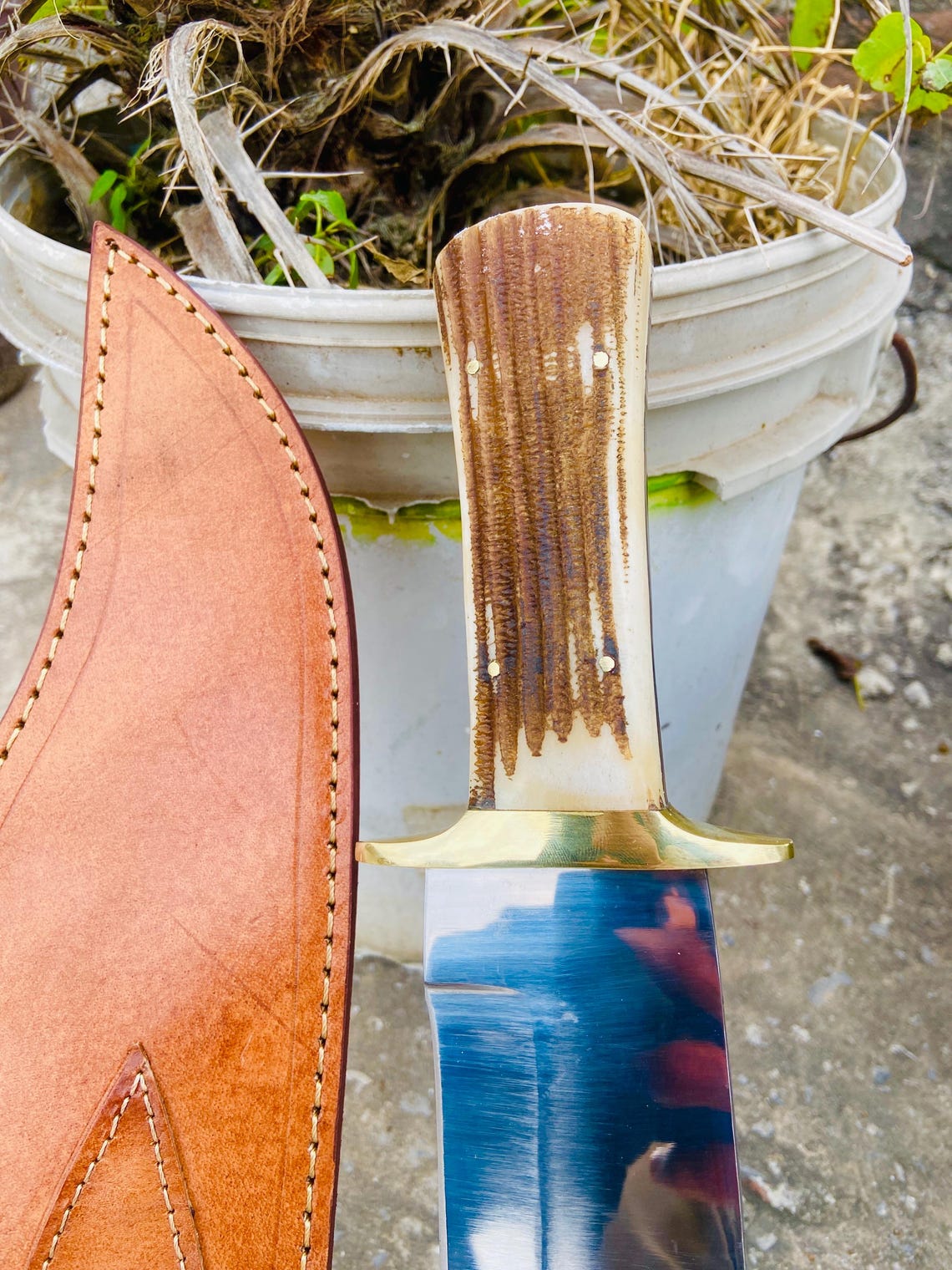 Handmade D2 bowie knife and sheath displayed as a gift for hunters and outdoor lovers.