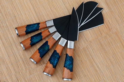 This chef set includes 5 handmade knives forged from black carbon steel and fitted with resin handles. Strong and balanced for daily kitchen use, BBQ, or outdoor cooking. Supplied with a leather sheath, with free engraving for a personalised finish.