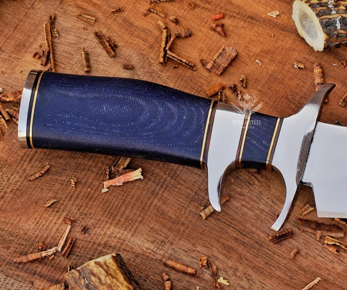Leather sheath with artificial skin panel and handmade bowie knife laid on display.