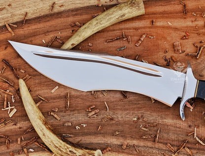 Close-up of polished D2 steel bowie blade with dual fuller detailing