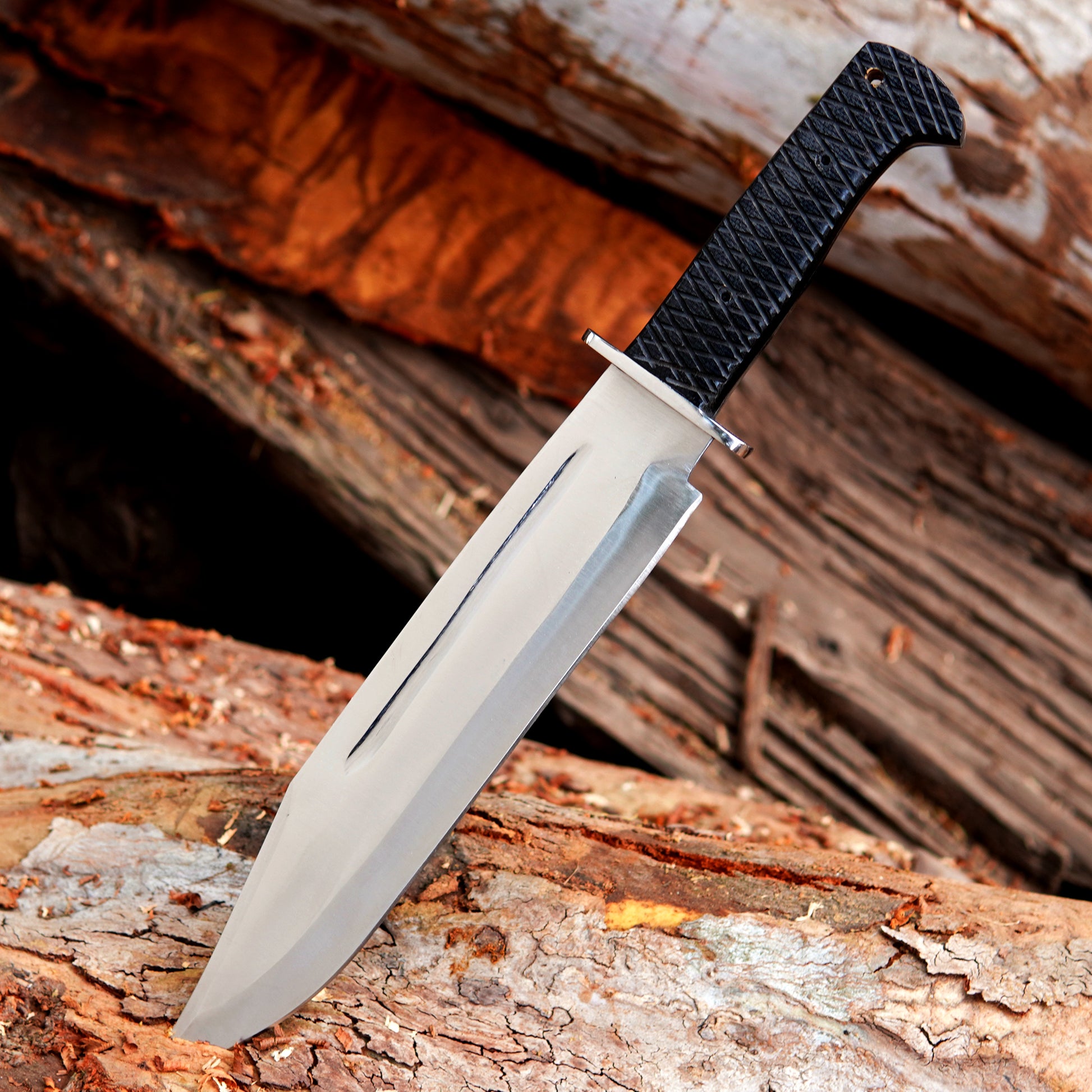 Close up blade detail of handmade carbon steel bowie knife showing clean finish and strong spine construction designed for durability control and long term performance in outdoor environments and general utility tasks.