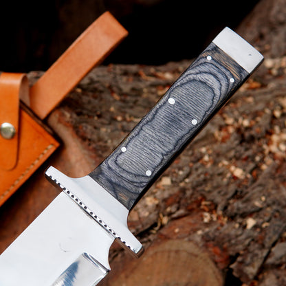 Fixed blade bowie knife photographed outdoors with polished blade reflecting natural light, emphasizing clean grind lines and durable construction. The image focuses on strength, balance, and usability for outdoor activities such as camping and bushcraft while presenting a premium handmade look suitable for collectors and enthusiasts.