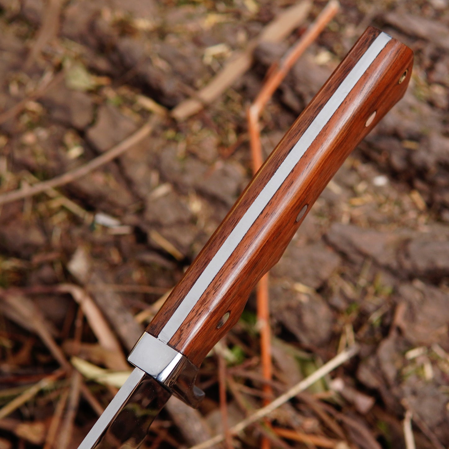 Detailed image of bowie knife handle showing natural material grip, secure pin construction and comfortable shape designed for stability and control during outdoor activities.