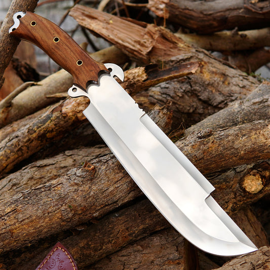 Handmade bowie style knife featuring a polished spring steel blade and hardwood handle displayed on natural wood.