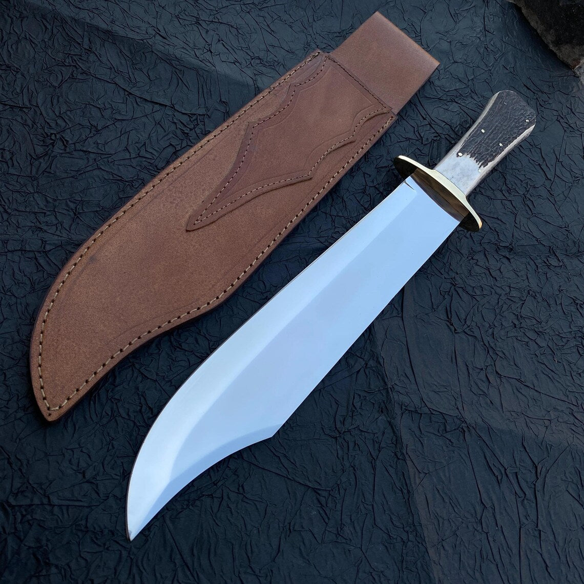 Carbon steel Bowie knife paired with handmade brown leather sheath.