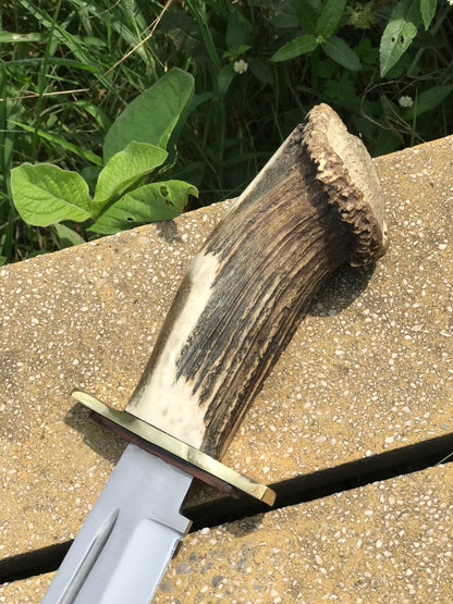 Close-up of the carbon steel blade and brass guard of a handmade Bowie knife with a genuine stag handle, highlighting its mirror polish and precision edge. Ideal for outdoor adventures, survival, and as a luxury gift for men who appreciate handcrafted hunting gear.
