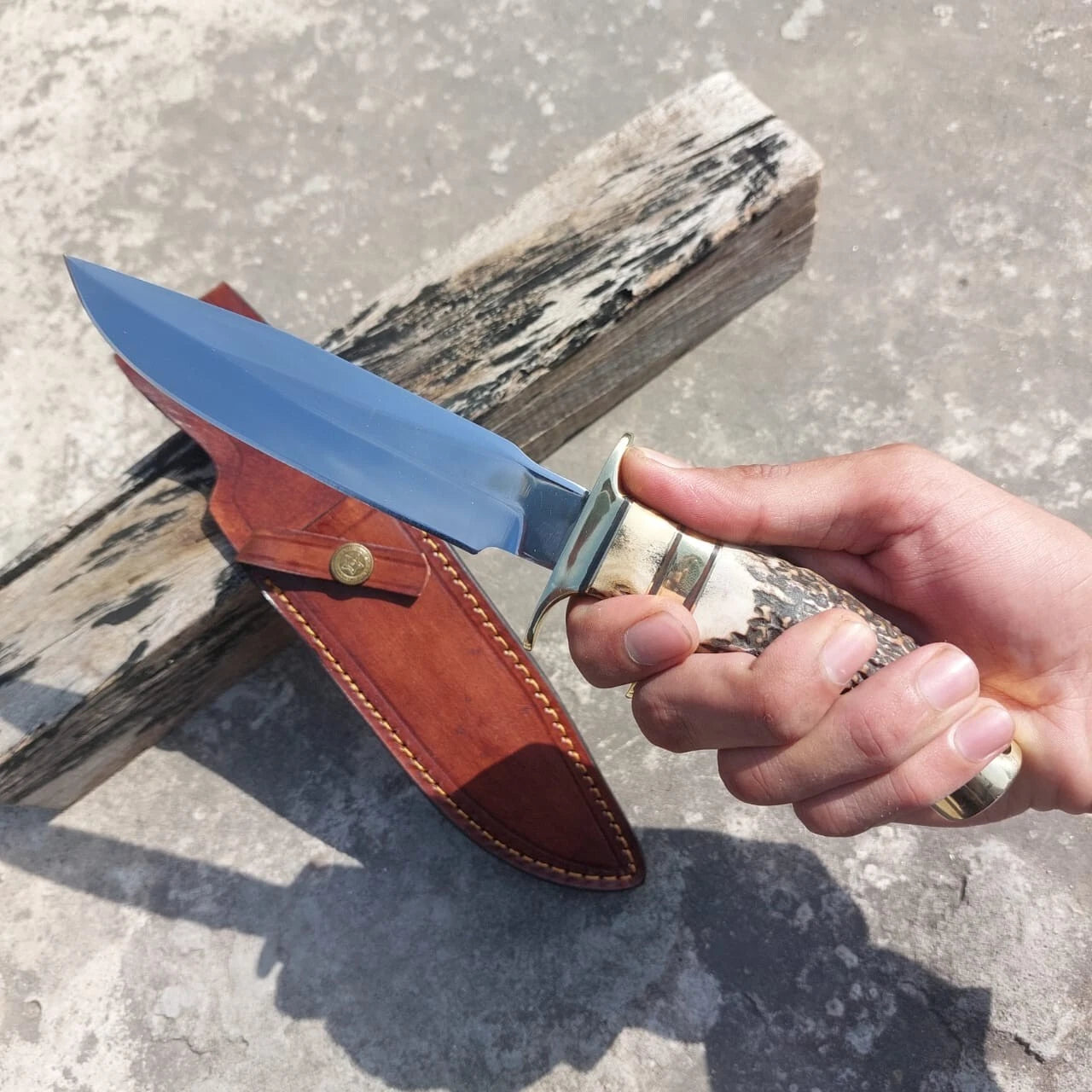 High carbon steel subhilt hunting knife with brass guard, polished finish, and leather sheath. A durable and versatile knife built for hunting, camping, and survival use, while also appealing as a collectible handcrafted blade.