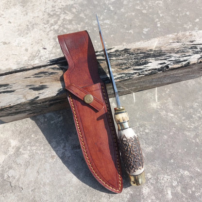Handmade outdoor hunting knife crafted with high carbon steel blade, subhilt guard, and brass fittings. This knife includes a stitched leather sheath for protection, designed for hunters, campers, and collectors of handmade knives.