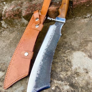 Outdoor display of carbon steel machete knife ideal for hunting or camping.