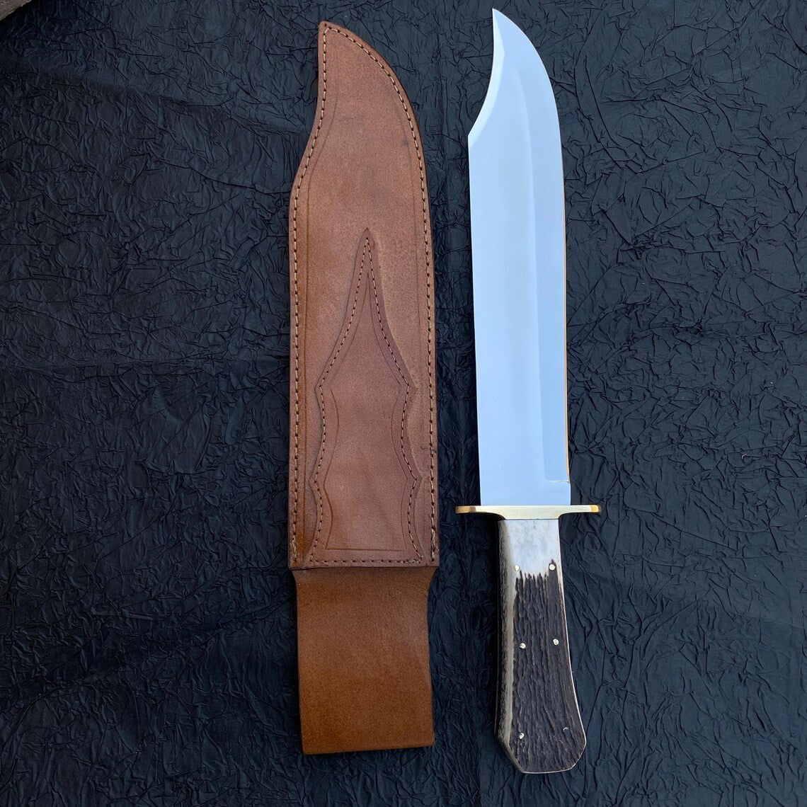 Full tang handmade Bowie knife with stag handle and brass guard.