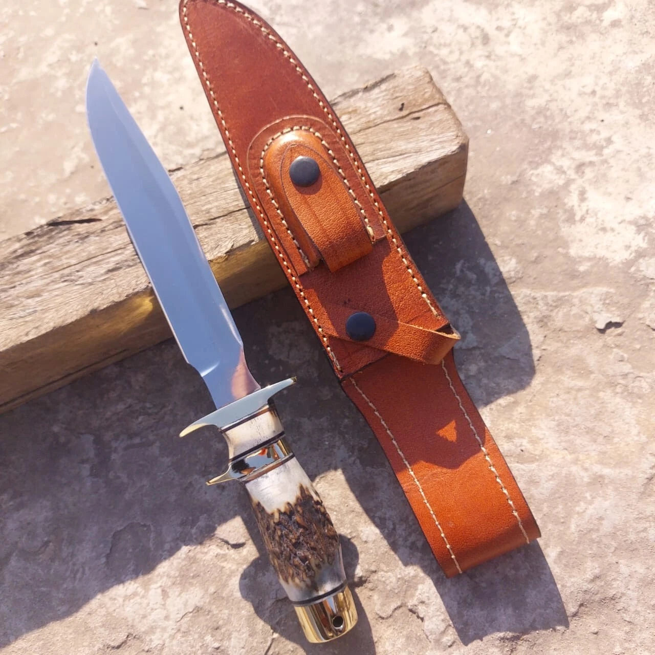 Custom handmade hunting knife with carbon steel mirror polished blade and stag handle. Strong brass fittings provide balance and secure grip. Comes with premium leather sheath for portability and storage, ideal for hunting, camping, and outdoor adventures.