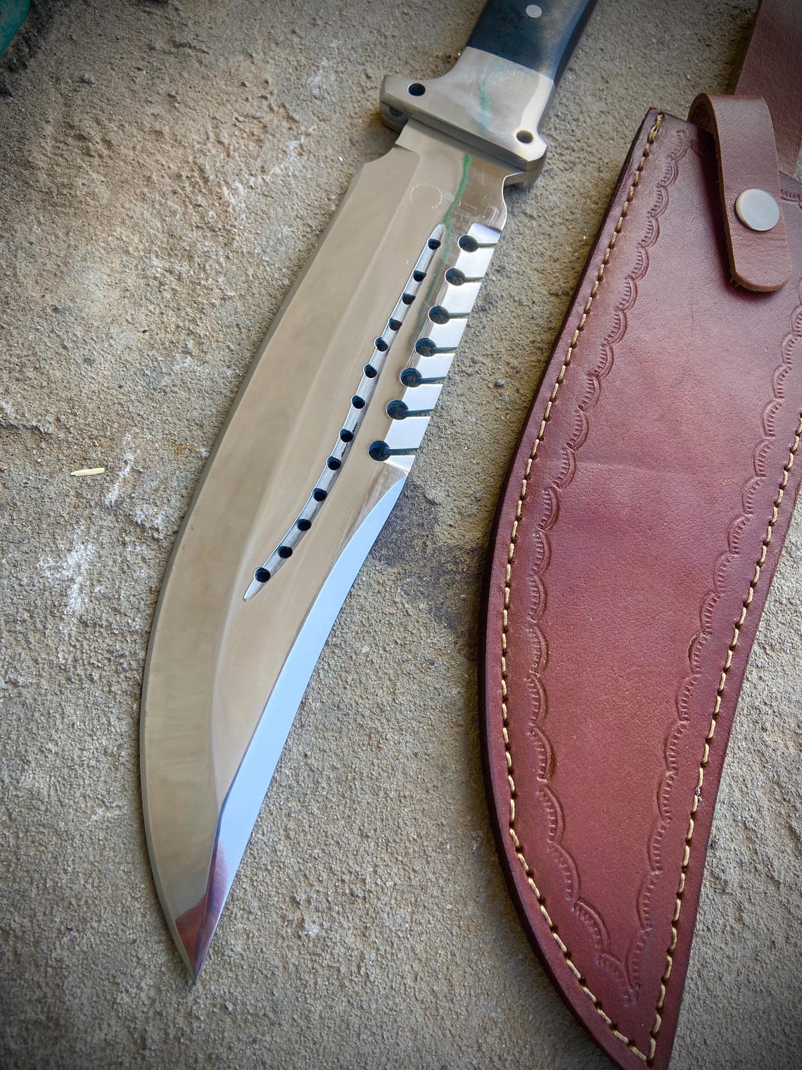 Outdoor survival bowie knife with polished carbon steel blade and dual-tone handle.