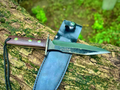 Full tang fixed blade hunting knife displayed on tree trunk showing craftsmanship and handle detail.