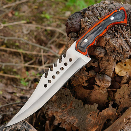 Outdoor lifestyle photo showing the knife on natural ground with trees and leaves creating a rugged survival setup that highlights its use as a dependable hunting and camping tool.