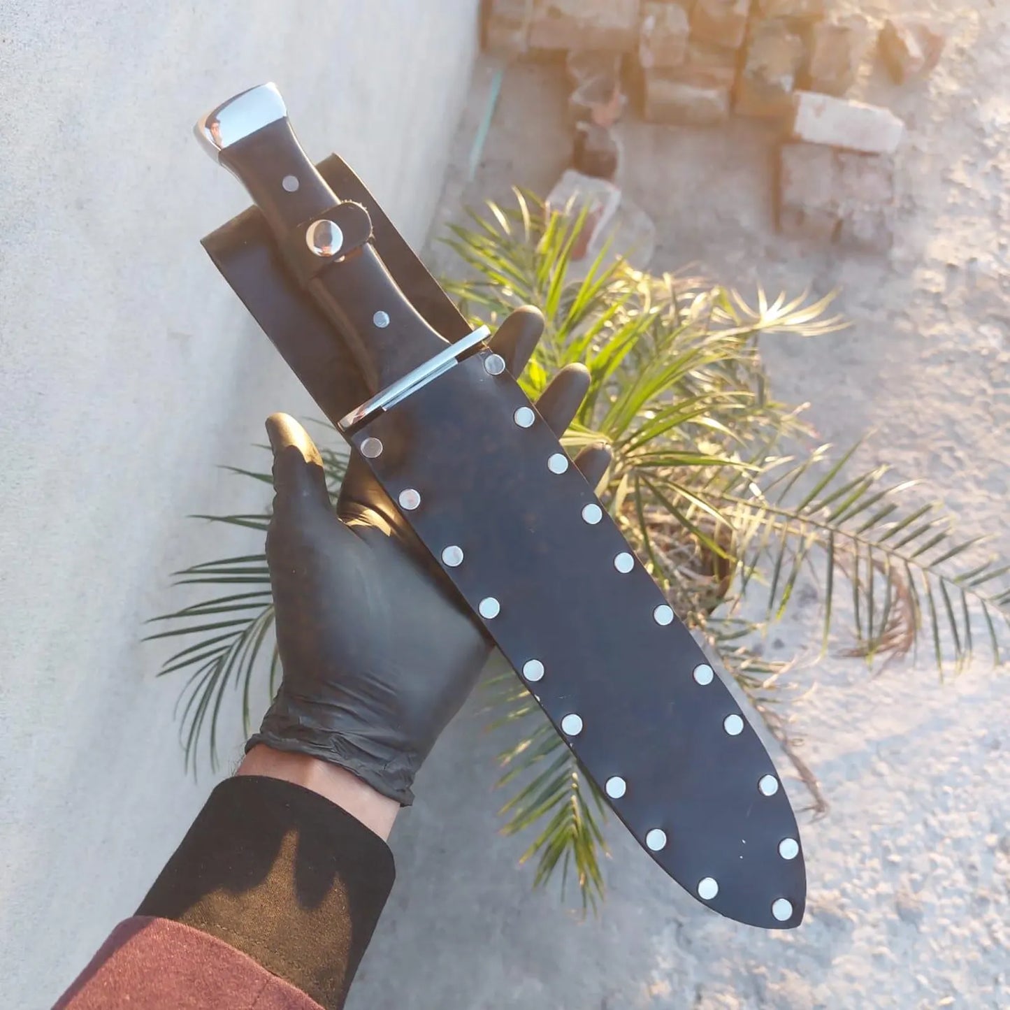 Double edge short sword displayed with leather scabbard.