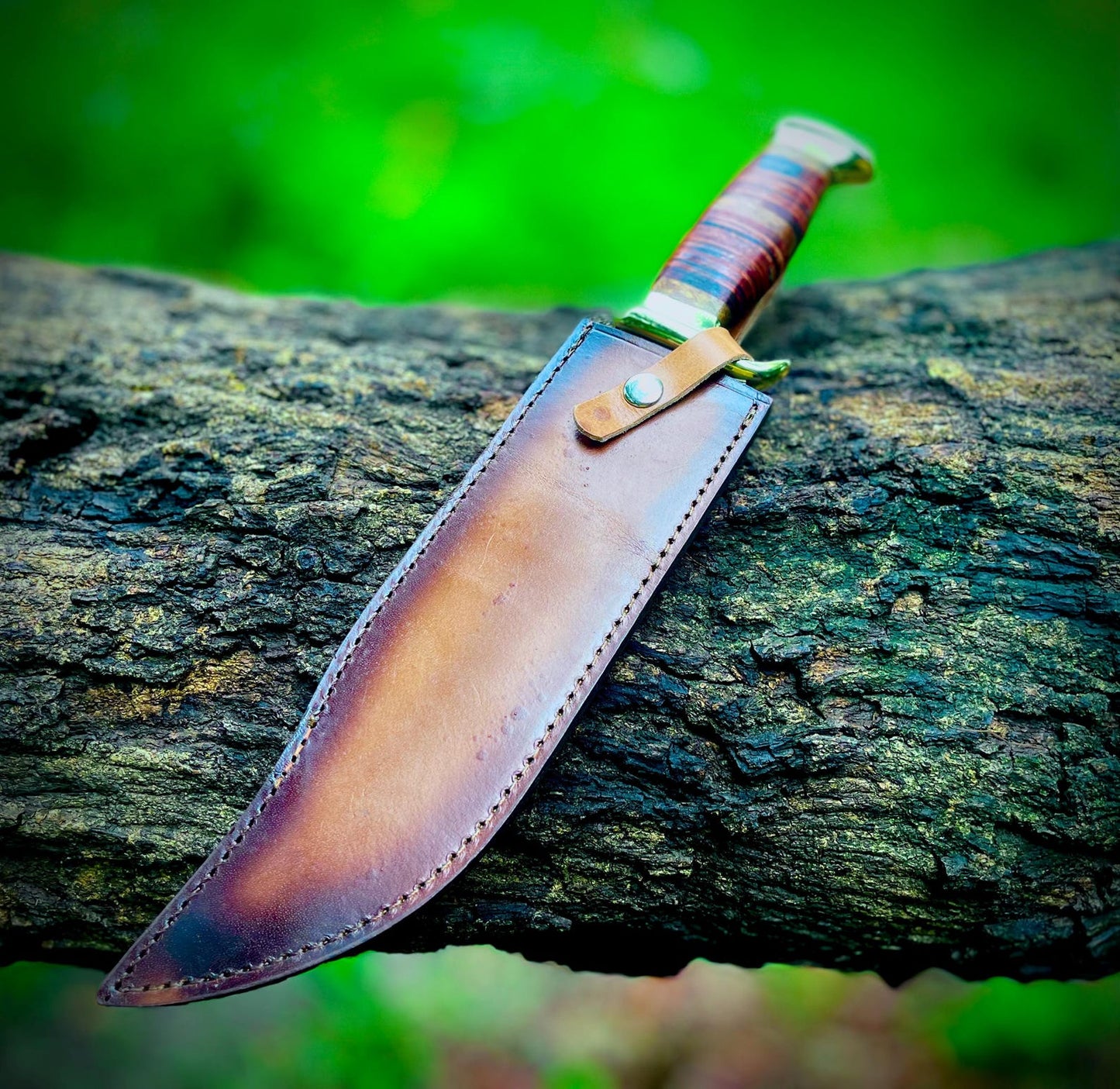 Close-up view of the Crocodile Dundee Bowie knife handle, featuring stacked leather grip with brass guard and pommel for strength and elegance. The carbon steel blade is paired with a brown stitched leather sheath, showcasing the knife’s durability and handmade quality. Perfect for serious collectors, outdoor survivalists, and knife enthusiasts who want a legendary Bowie knife design.
