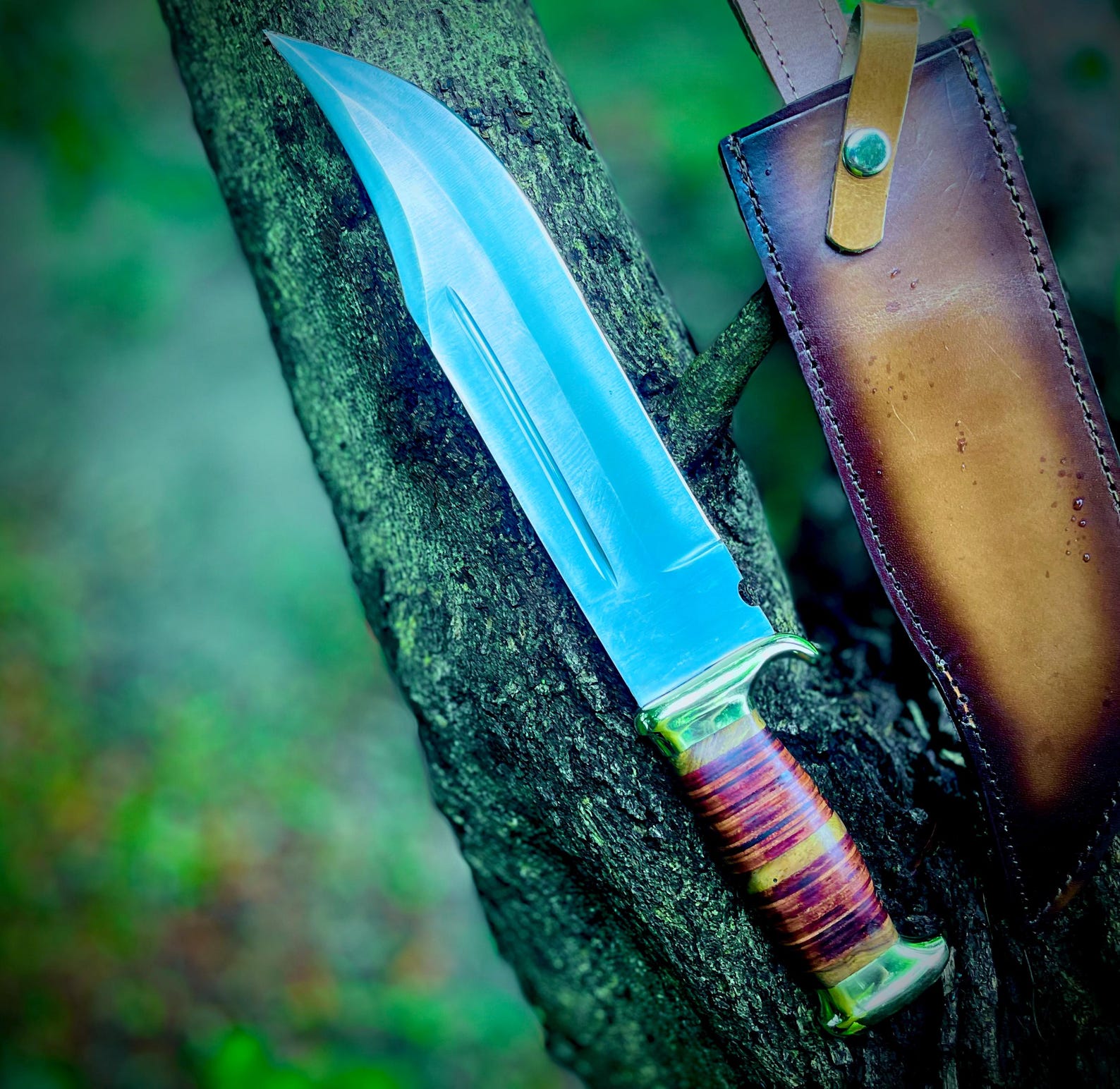 Authentic handmade Crocodile Dundee Bowie knife with a wide carbon steel blade, brass guard, and stacked leather handle, displayed with a custom brown leather sheath. Known for its strength and legendary design, this knife is ideal for knife lovers, collectors, and outdoor enthusiasts. Handmade craftsmanship ensures every detail, from blade polish to sheath stitching, is premium quality.