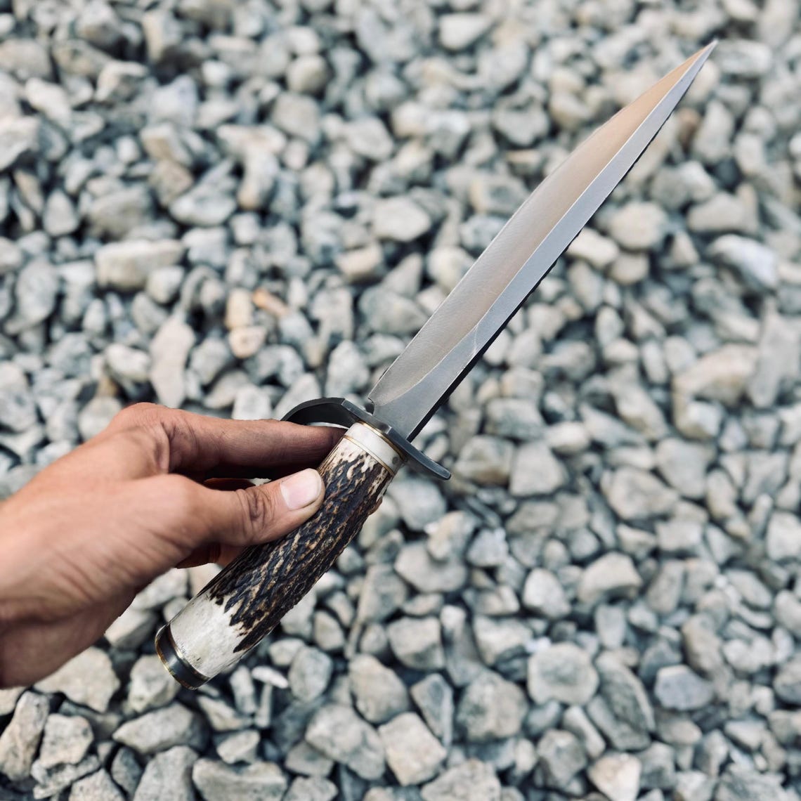 Custom handcrafted Bowie knife made from 5160 spring steel with a natural stag handle and detailed brass fittings. Designed for power, precision, and heritage value.