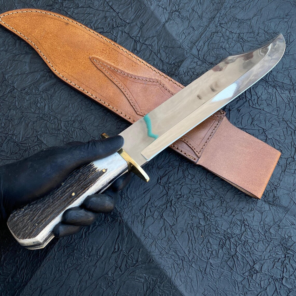 Outdoor display of polished handmade hunting Bowie knife.
