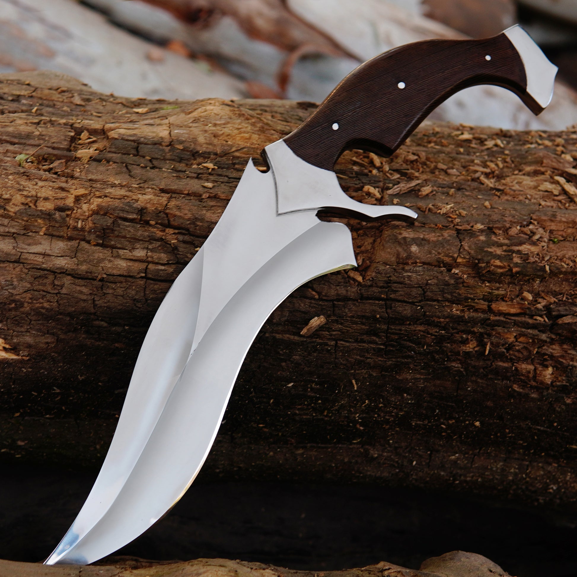Outdoor hunting bowie knife with curved blade and natural material handle placed on wooden logs to create an authentic outdoor environment. The image focuses on blade shape, clean finish, and strong full tang construction while presenting the knife as a practical outdoor companion and handcrafted gift option.