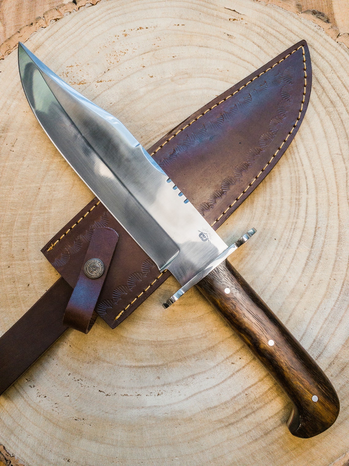 Custom handmade Bowie knife with a polished carbon steel blade and full tang construction, paired with a rich wooden handle. Designed for survival, outdoor, and hunting use, offering excellent grip and durability. A perfect gift for collectors, hunters, or knife lovers who appreciate craftsmanship and performance.