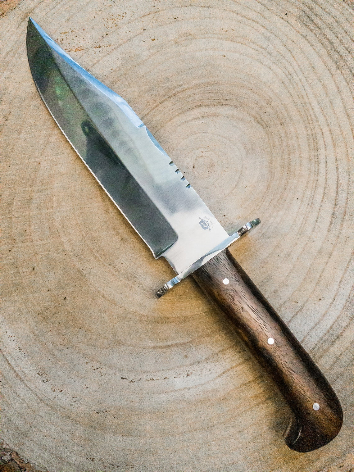 Handmade carbon steel Bowie knife crafted for strength and beauty with a full tang design and hardwood handle. Perfect for hunting, camping, and collecting, this knife combines traditional craftsmanship with modern performance.