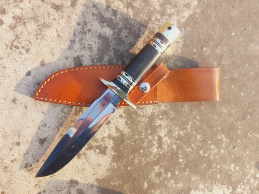 Handmade hunting knife with micarta handle, mirror-polished blade, and brass guard. The knife includes a stitched leather sheath for safe storage, making it ideal for hunters, outdoor adventurers, and collectors who value strength, durability, and craftsmanship.