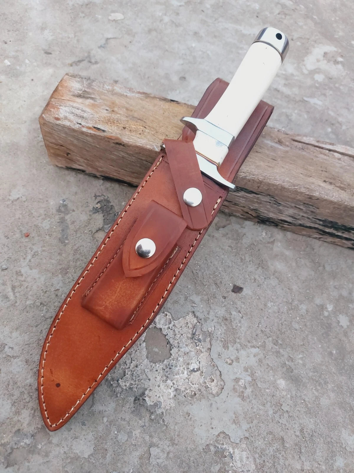 Outdoor Damascus hunting knife with subhilt design for control, bone handle grip, and layered steel blade. Comes with leather sheath for portability. Suitable for hunters, outdoor adventurers, and knife enthusiasts.