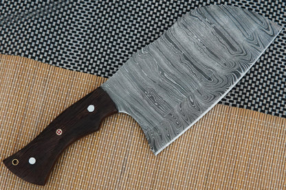 A Damascus cleaver knife handmade with a full tang blade and wenge wood handle. Built to last for meat cutting, BBQ, or outdoor cooking. Makes a great personalised gift with free engraving offered on blade or sheath.