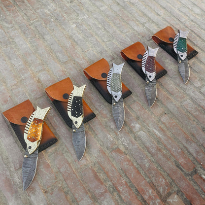 Damascus folding pocket knife open blade view showing patterned steel blade and fish style handle design.
