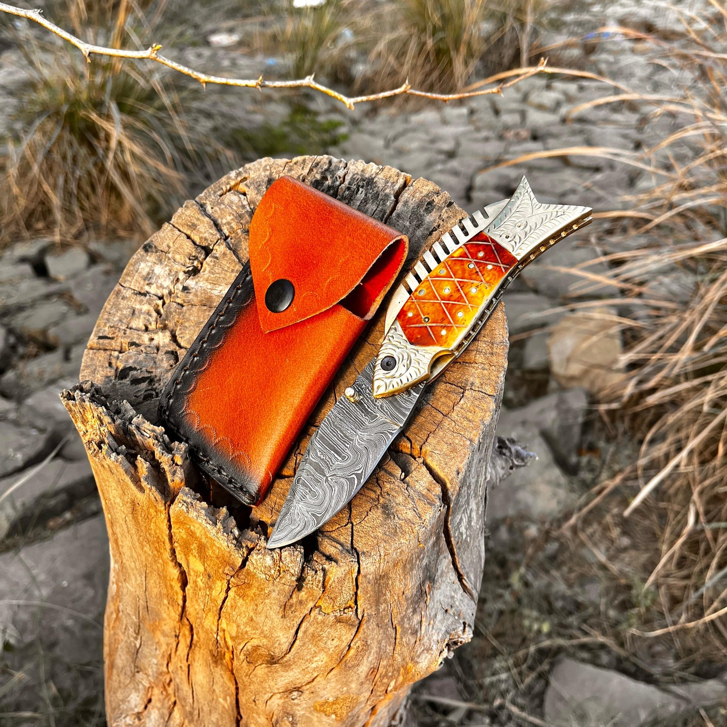 Close view of Damascus fish pocket knife showing detailed blade pattern and decorative fish style handle with engraving option.