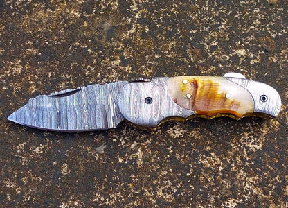 Hand-forged Damascus EDC pocket knife showing intricate file work and engraved coin back design.