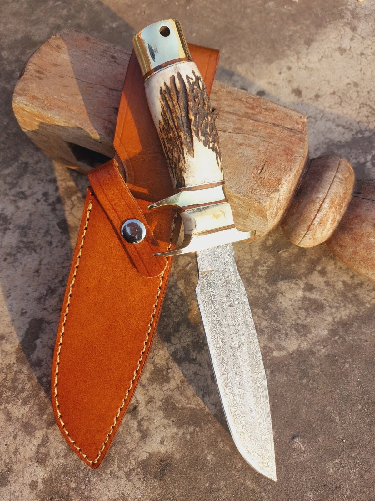 Fixed blade damascus hunting knife with unique forged design and traditional natural handle. The brass guard and pommel provide balance and security, while the hand stitched leather sheath offers safe storage and portability. Ideal for outdoor lovers and collectors of handmade knives.