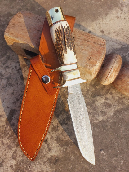 Fixed blade damascus hunting knife with unique forged design and traditional natural handle. The brass guard and pommel provide balance and security, while the hand stitched leather sheath offers safe storage and portability. Ideal for outdoor lovers and collectors of handmade knives.