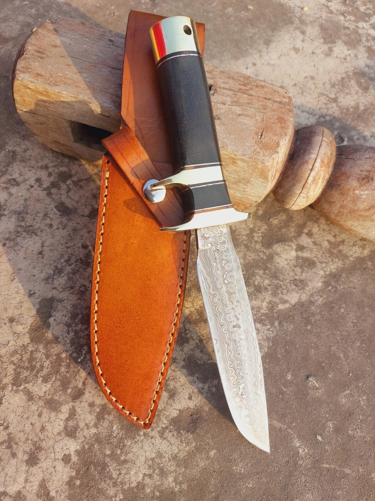 Outdoor Damascus steel subhilt knife with micarta handle, designed for hunters and adventurers. The strong blade showcases detailed forging patterns, paired with brass guard and butt cap. Comes with leather sheath for portability and protection.