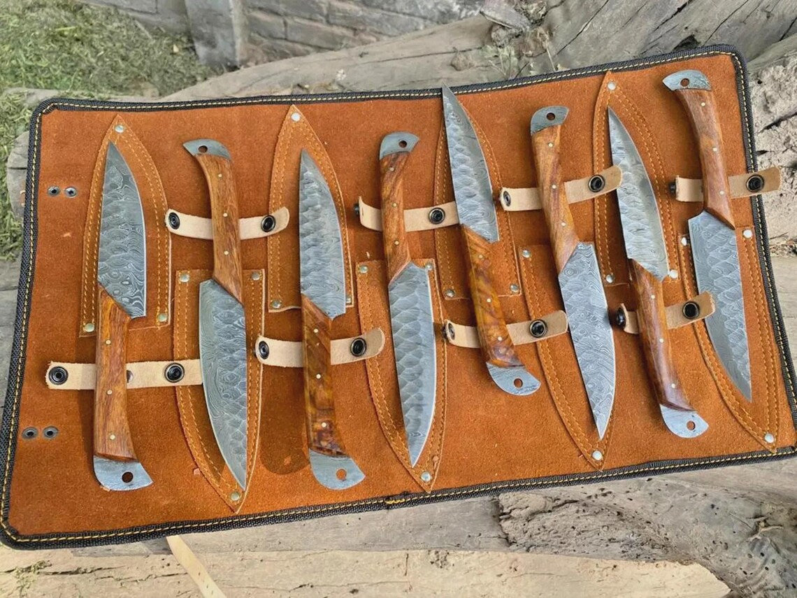 8 piece Damascus steak knife set displayed in leather roll for kitchen and outdoor dining
