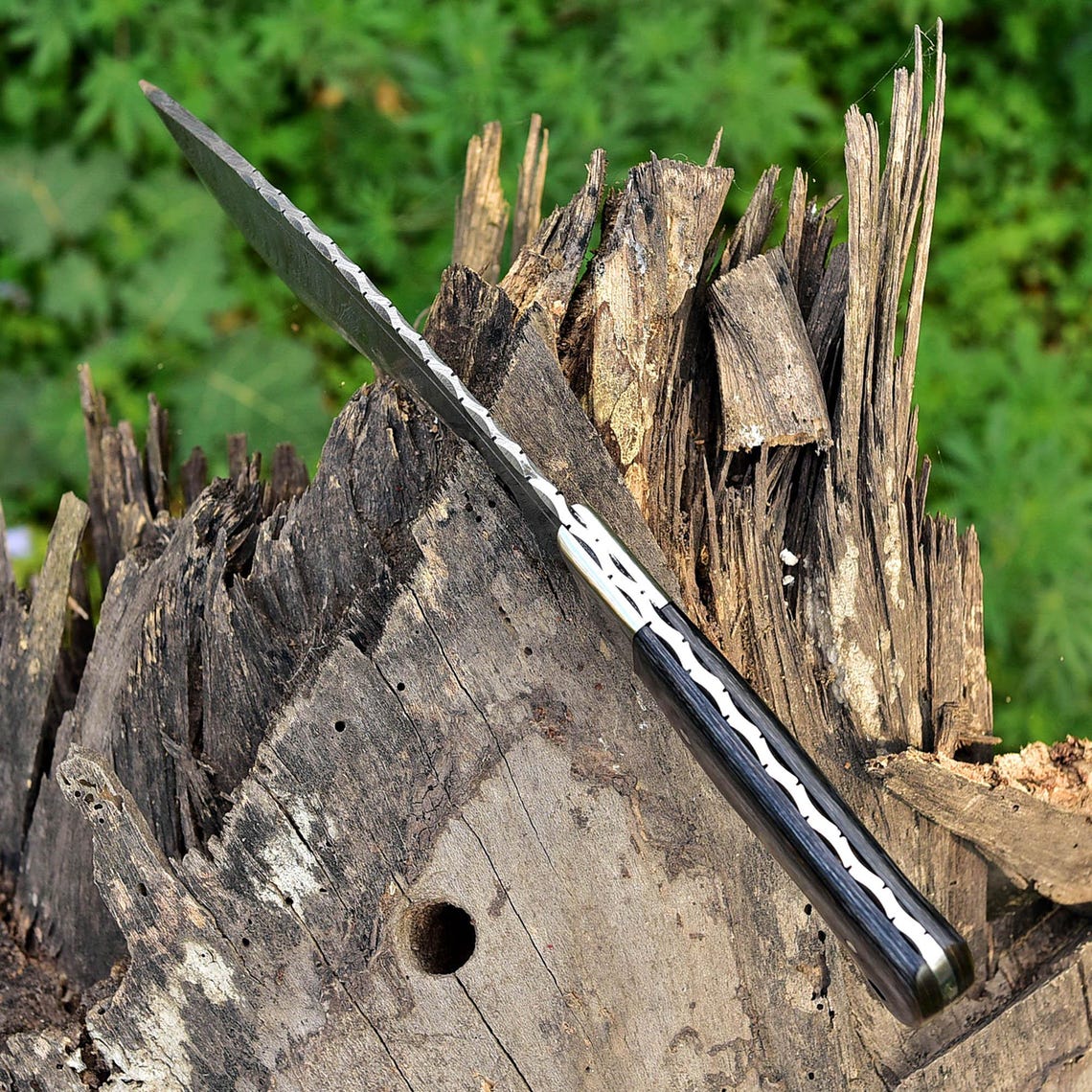 Close-up view of the detailed spine file work and Damascus pattern, showing precision craftsmanship and superior forging quality.