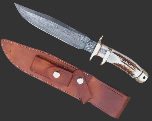 Damascus hunting knife crafted with a subhilt blade for control and a stag antler handle for comfort. Each knife is unique due to the layered Damascus forging process. Supplied with a stitched leather sheath, ideal for hunting, camping, or as a collectible handmade knife.