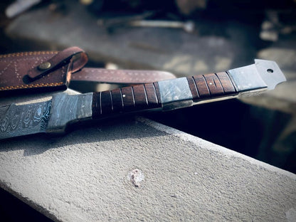 Full tang handmade Viking sword with leather sheath displayed on stone ledge.