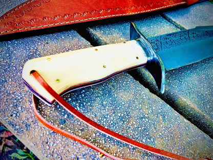 Close-up view of sandbar bowie knife handle showing polished natural material grip and engraved steel blade detail.
